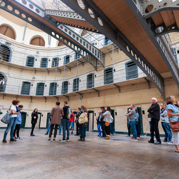 August 2019: A tour group on the floor of the Victorian main hall in the Kilmainham Gaol, a former prison which is now a museum.