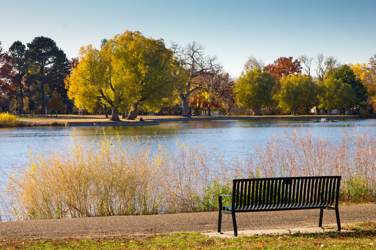 Empty bench by lake with Fall trees - Washington Park - Denver, Colorado