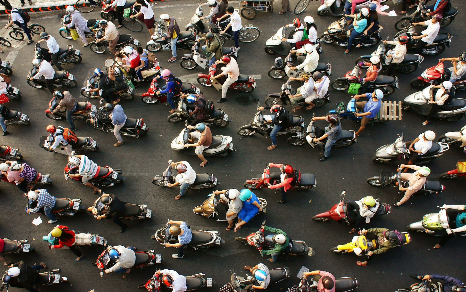 Dense, crowed scene of city traffic in rush hour, crowd of people wear helmet, transport by motorcycle,