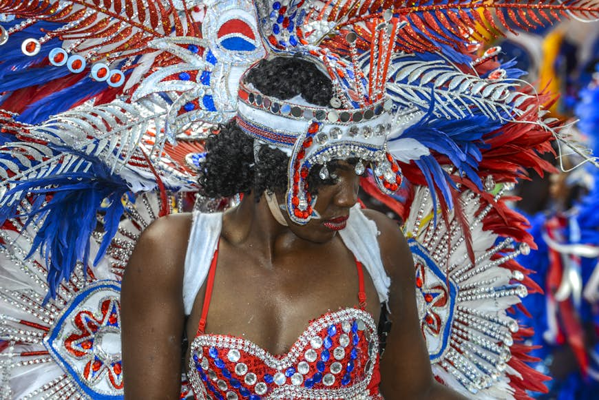 En dansare i traditionell färgglad röd och silverdräkt på Junkanoo Festival i Nassau, Bahamas 