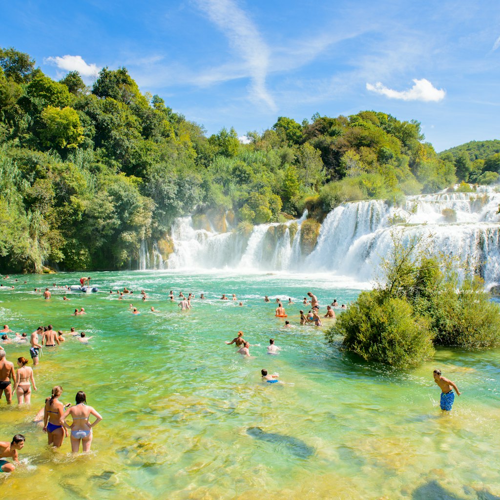 KRKA NATIONAL PARK, CROATIA - AUG 26, 2014: Unidentified tourists swim in the Krka River in the Krka National Park in Croatia. It is one of the National Parks in Croatia with an area of 109 km2