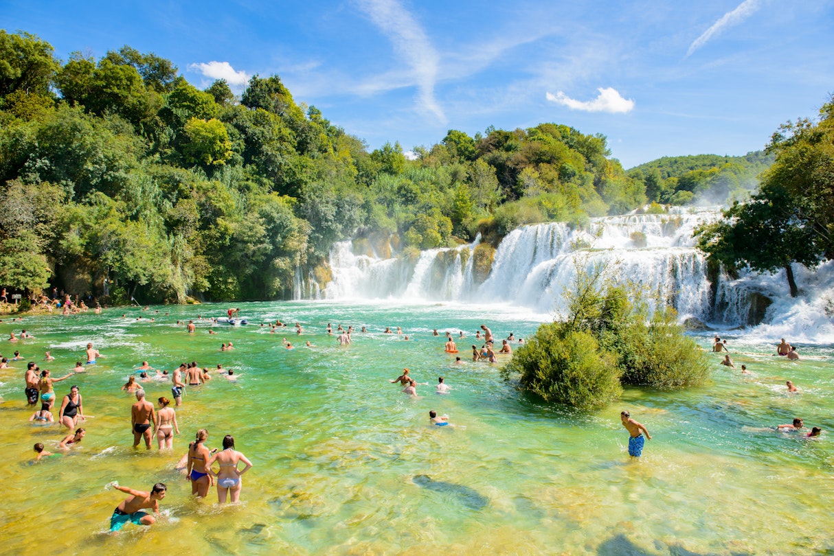 KRKA NATIONAL PARK, CROATIA - AUG 26, 2014: Unidentified tourists swim in the Krka River in the Krka National Park in Croatia. It is one of the National Parks in Croatia with an area of 109 km2