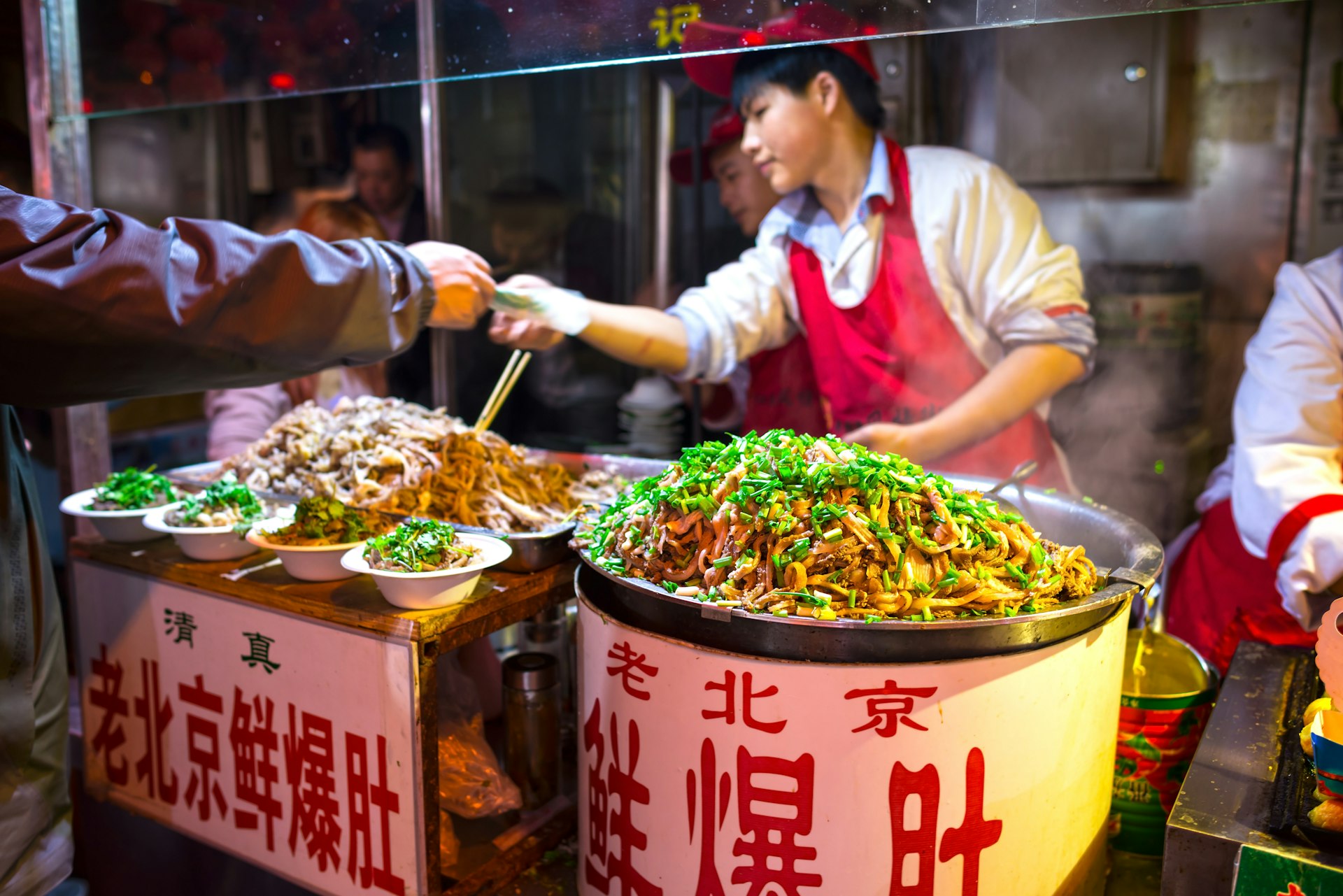 一位厨师从街上的一个零食摊上出售猪肉肚。