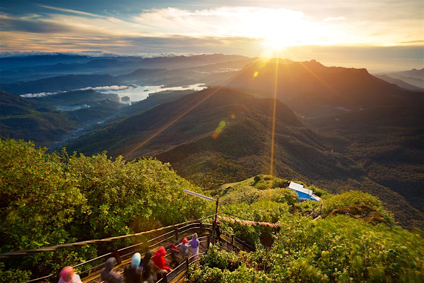 The view looking down into the green valley from the top of Adam's Peak, a famous hill in Sri Lanka. Pilgrims make their way down from the summit via a path.