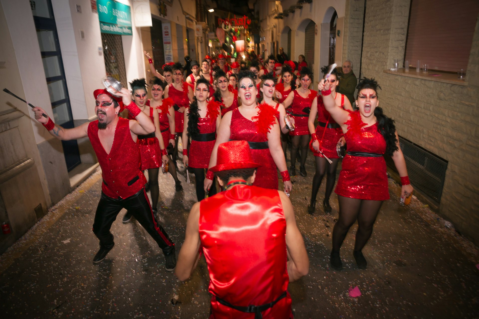 A band of men and women dressed only in red and black at a Carnaval parade