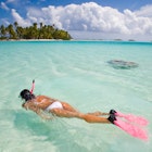 active woman free diving snorkeling in beautiful blue ocean on summer vacation.