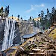 A male hiker standing on stone steps and admiring a waterfall in Yosemite National Park.