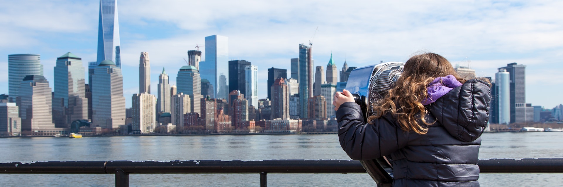 JERSEY CITY, NJ - MARCH 6: A little girl looks at the Manhattan skyline through binoculars at Liberty State Park on March 6, 2016.