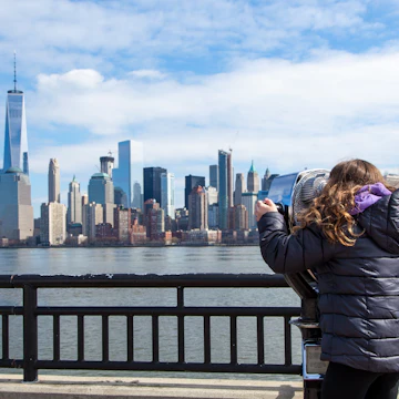 JERSEY CITY, NJ - MARCH 6: A little girl looks at the Manhattan skyline through binoculars at Liberty State Park on March 6, 2016.