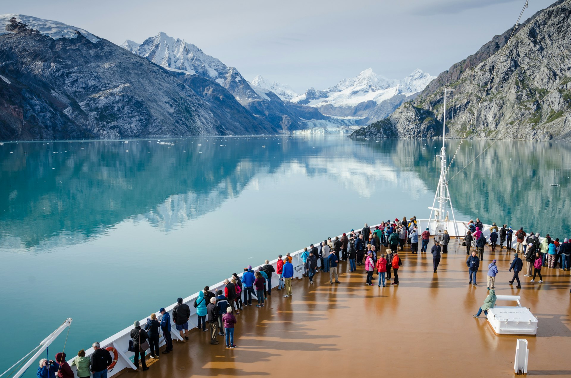 The deck of a cruise ship as it looks out over a bay and a glacier in the background