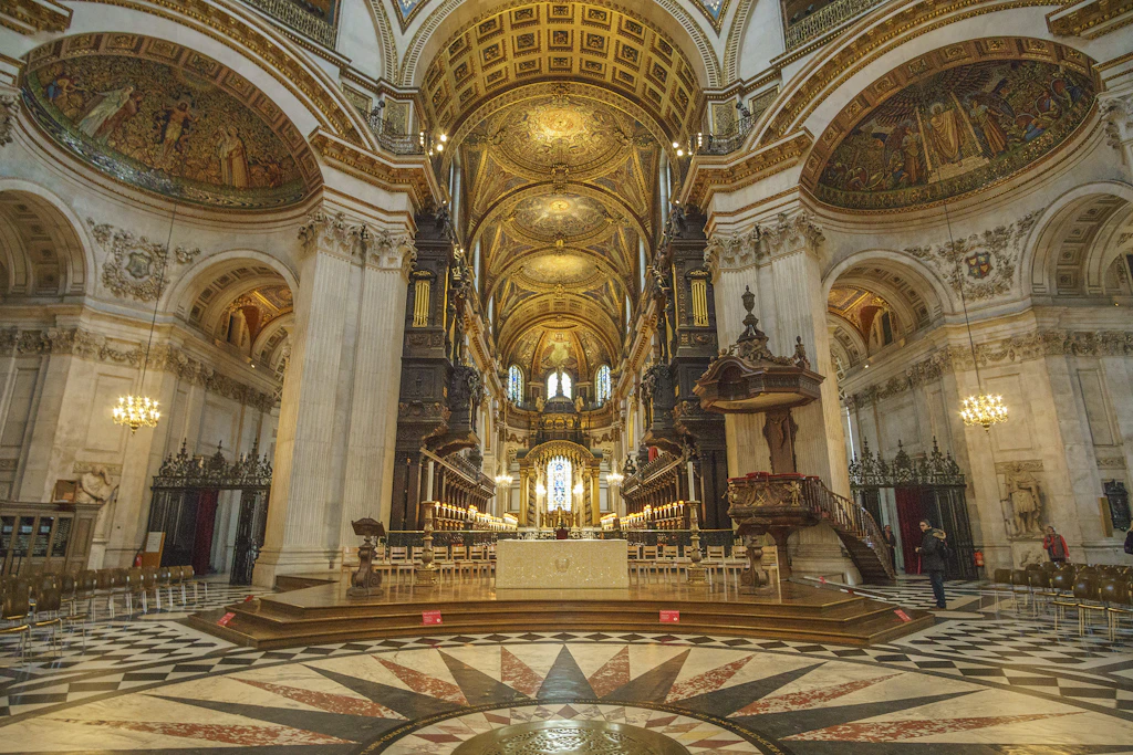 A vast room of white marble with gold finishings and huge vaulted ceilings 