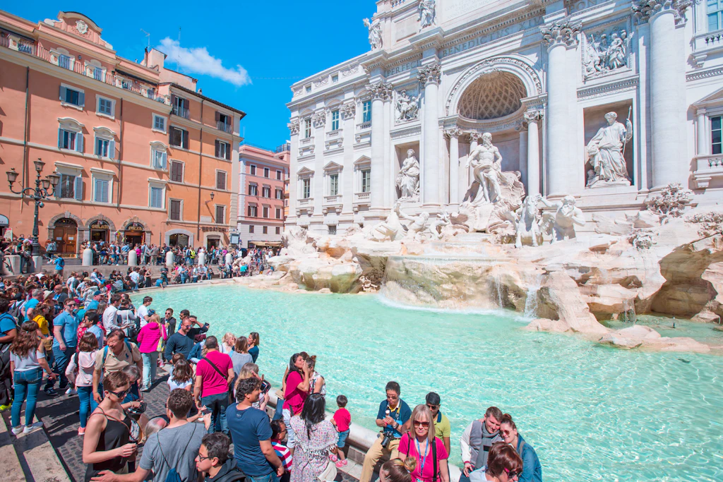 People gather at the pool in front of an ornate fountain in Rome