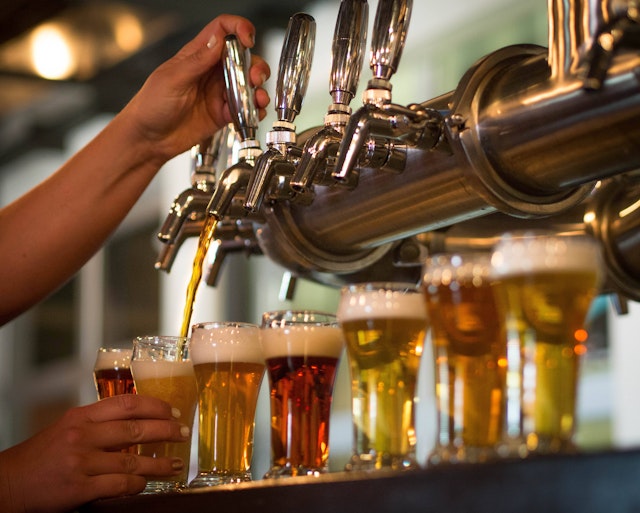 A bartender pours beer from a tap at a craft beer brewery in Colorado