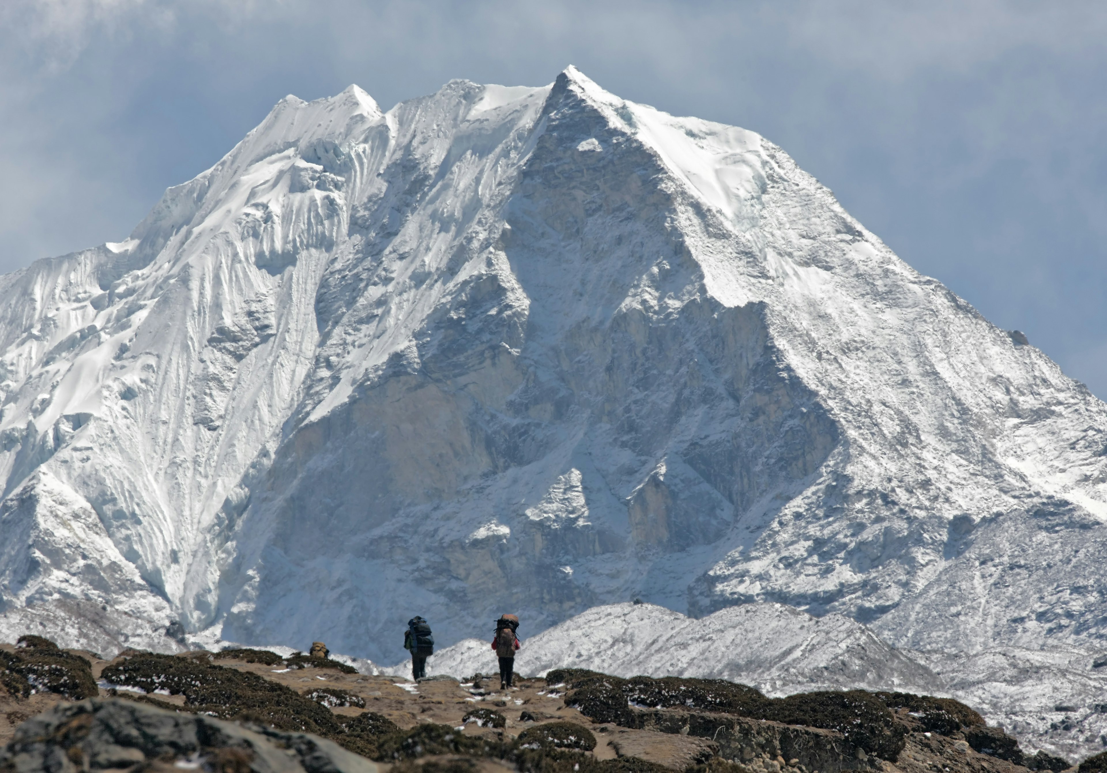 Trekkers against of snow-covered Island peak (6189 m)