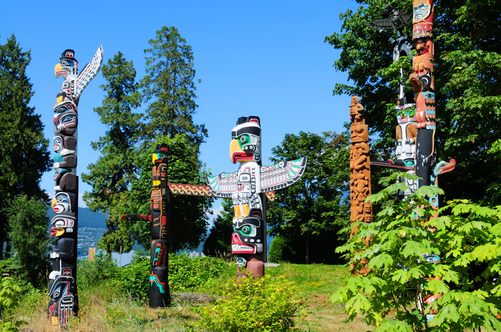 Totem poles First Nations totems stand in a forest.