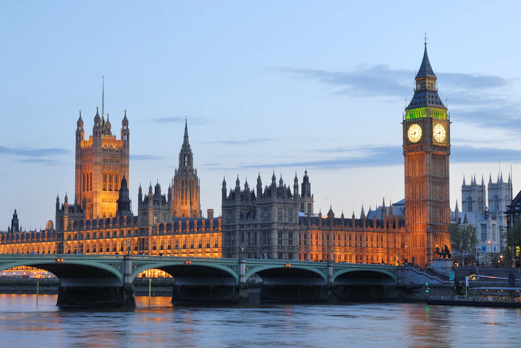 Long-exposure night photo of the Houses of Parliament (Palace of Westminster), a large Neo-Gothic building on the River Thames