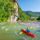 A kayaker is floating down the Buffalo River near Ponca, Arkansas. ; Shutterstock ID 1418391578; your: Ben N Buckner; gl: 65050; netsuite: Client Services; full: Arkansas Outdoor Adventures