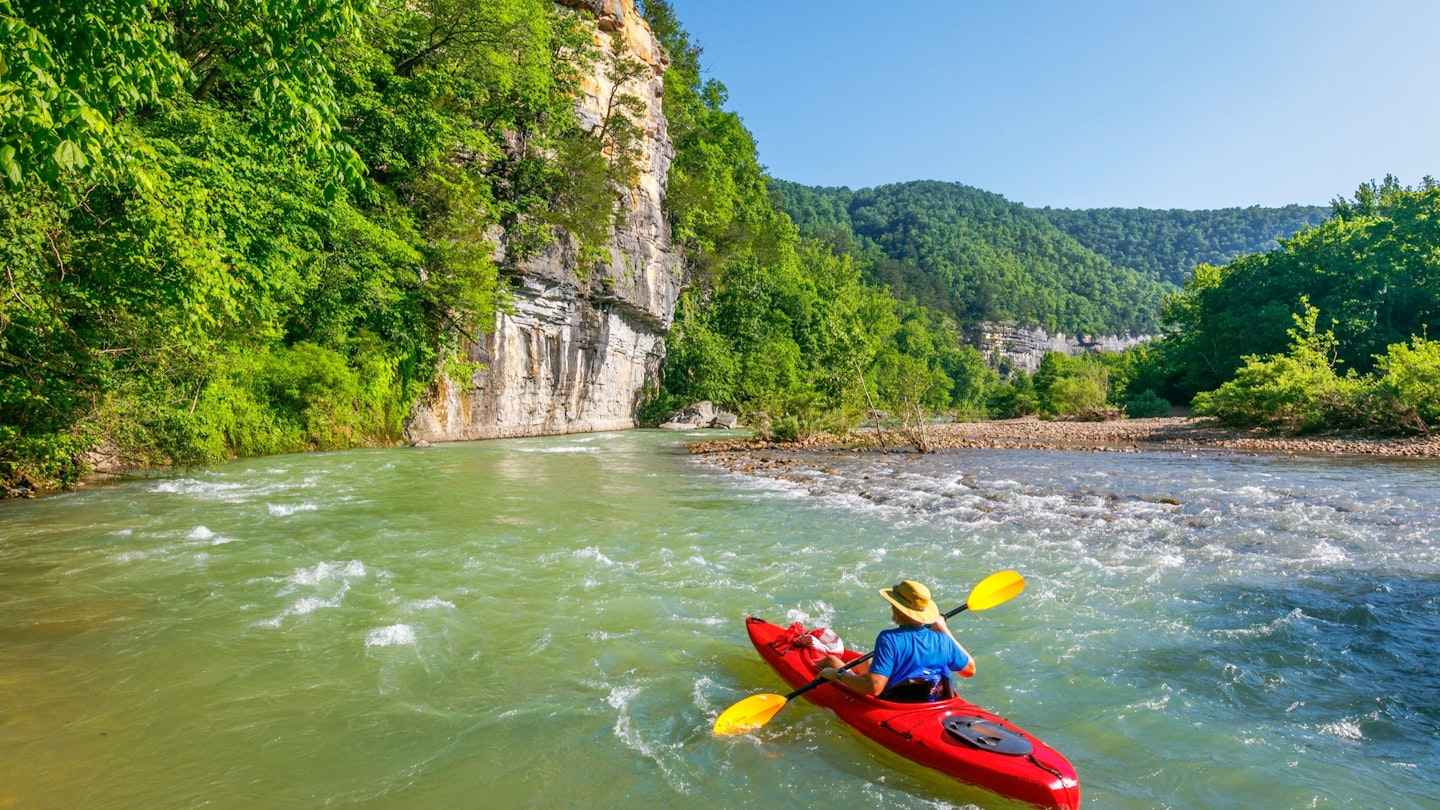 A kayaker is floating down the Buffalo River near Ponca, Arkansas. ; Shutterstock ID 1418391578; your: Ben N Buckner; gl: 65050; netsuite: Client Services; full: Arkansas Outdoor Adventures