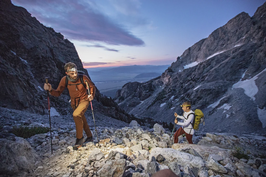 Two hikers climb through the dawn in the Teton backcountry, Wyoming