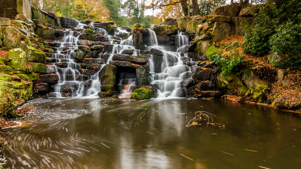 A waterfall cascading over rocks into a dark swirling pool