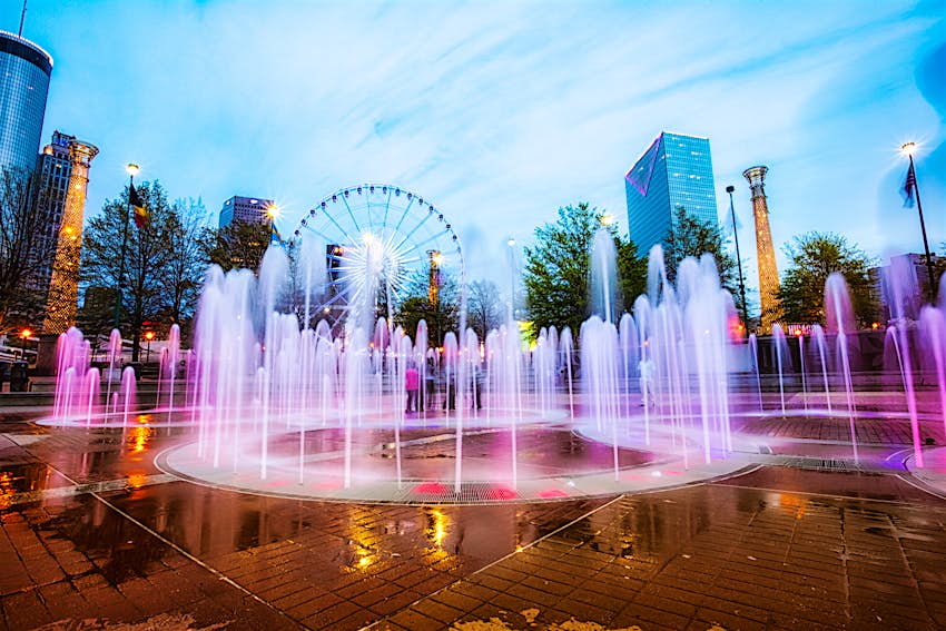 April 5, 2014: The colourfully lit fountain at Centennial Olympic Park with a Ferris wheel in the background.