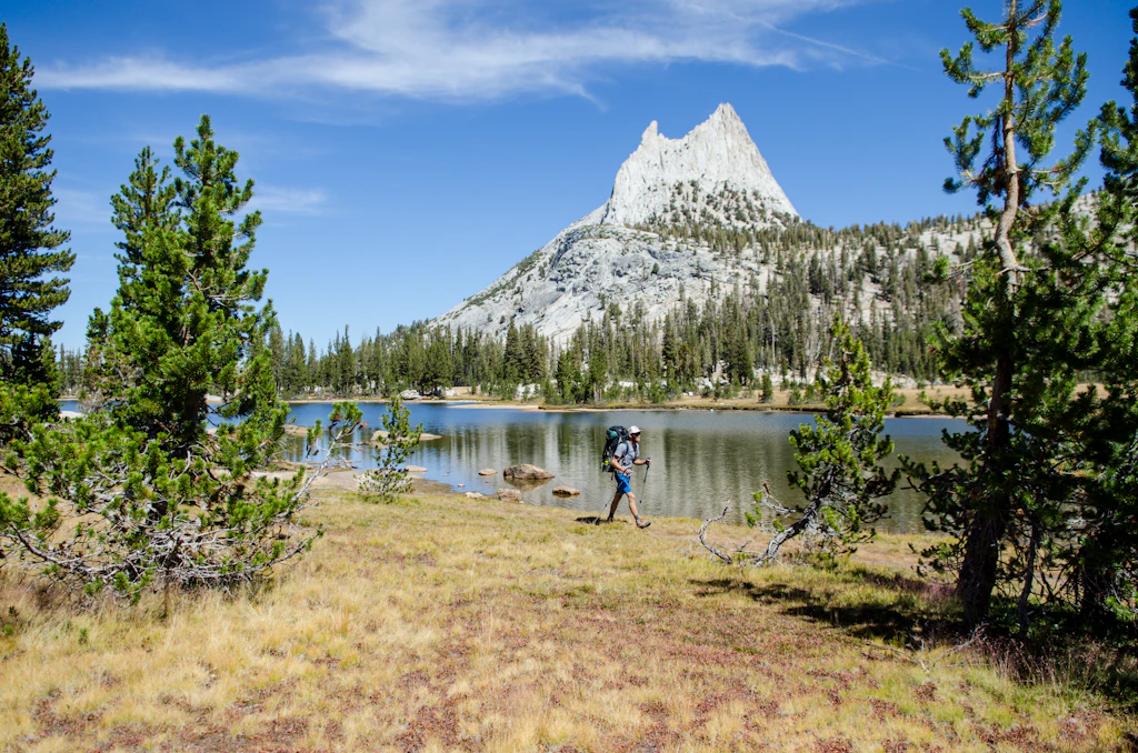 A young man walks past Cathedral Lake during a 27.3 mile backpacking trip from Tuolumne Meadows to Yosemite Valley, California.