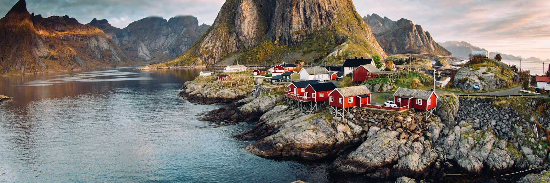 Norwegian fishing village of Hamnoy in the Lofoten Islands. Dramatic sunset clouds above steep mountain peaks.