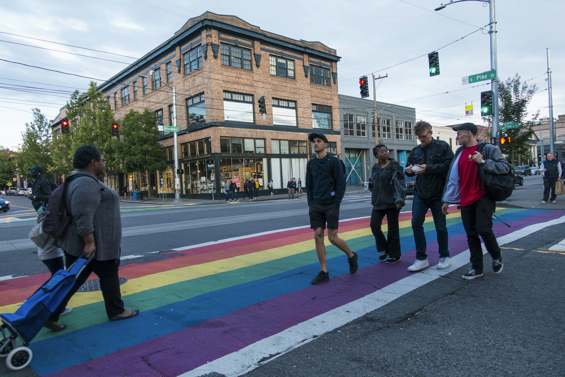 Pedestrians cross the street on a rainbow crosswalk on Capitol Hill at the Corner of East Pike St and Broadway