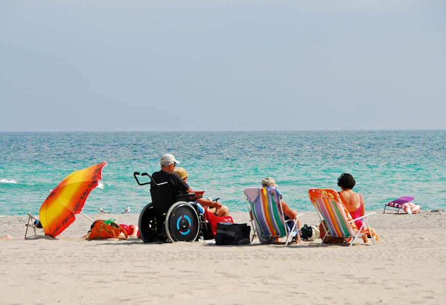 A man in a wheel chair on a beach