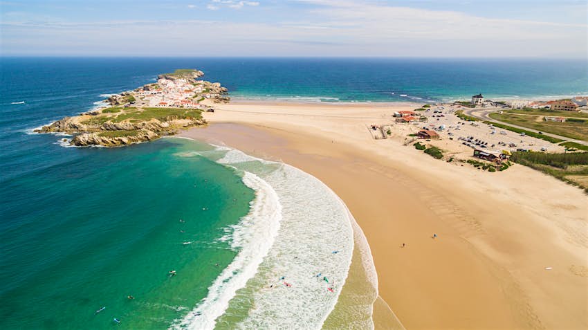 Priya du Compismo e a ilha de Bal Nairn na costa oeste de Portugal Vista aérea da ilha de Paleol, na costa de Portugal. A pequena ilha rochosa é o lar de uma pequena aldeia. A ilha está ligada ao continente por uma ponte de areia, com uma praia de cada lado.