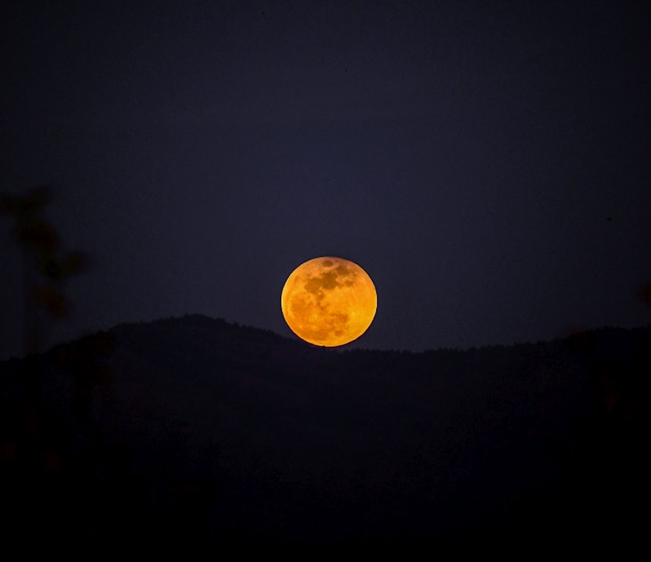 A picture taken on January 31, 2018 shows the moon rising behind a mountain during a lunar eclipse, referred to as the "super blue blood moon" near Syria-Turkey border at the Hassa district in Hatay..Stargazers across large swaths of the globe had the chance to witness a rare "super blue blood Moon" on January 31, 2018, when Earth's shadow bathed our satellite in a coppery hue. The celestial show was the result of the Sun, Earth, and Moon lining up perfectly for a lunar eclipse just as the Moon is near its closest orbit point to Earth, making it appear "super" large.. / AFP PHOTO / OZAN KOSE        (Photo credit should read OZAN KOSE/AFP via Getty Images)