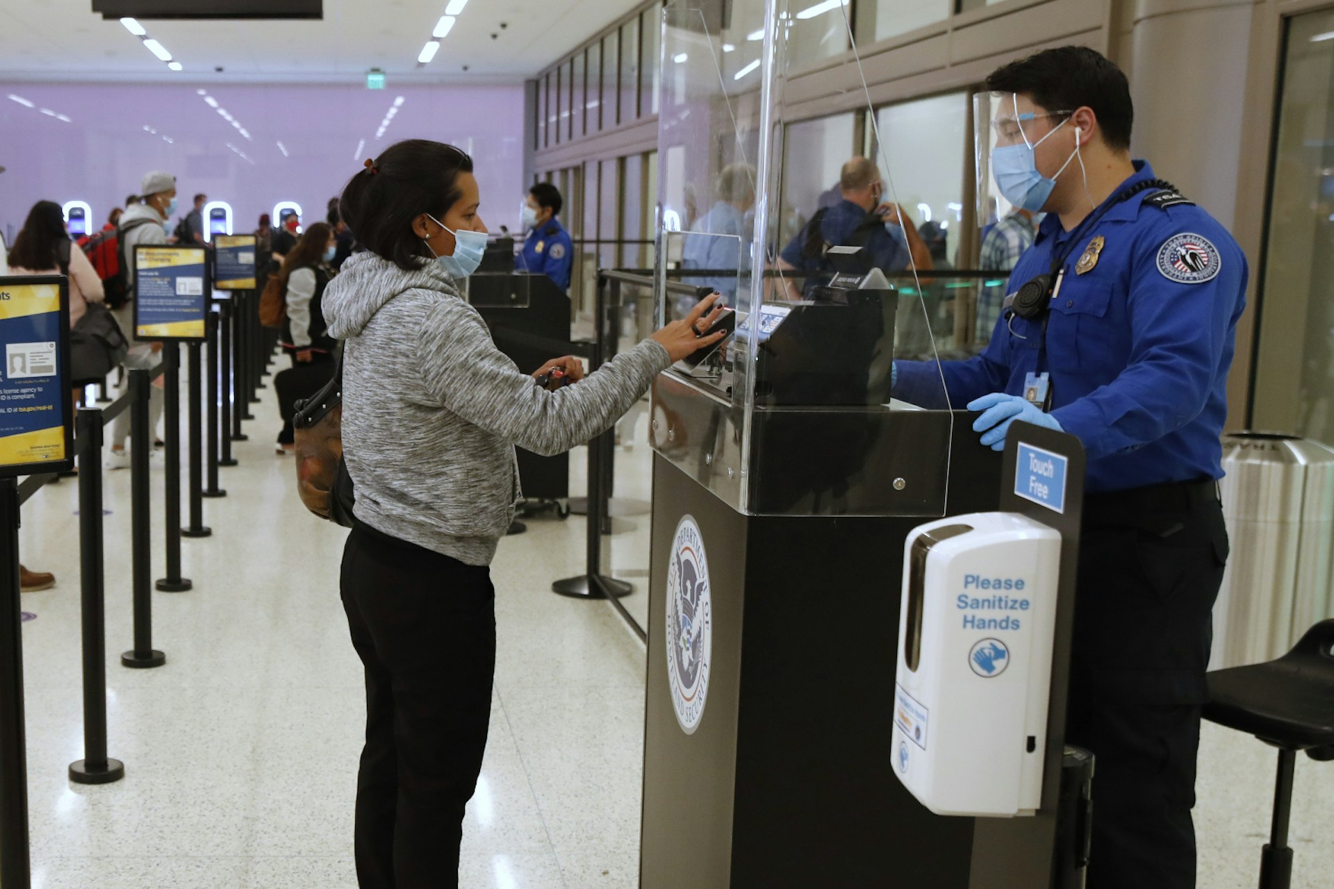 A woman having her documents checked at a TSA checkpoint at an airport