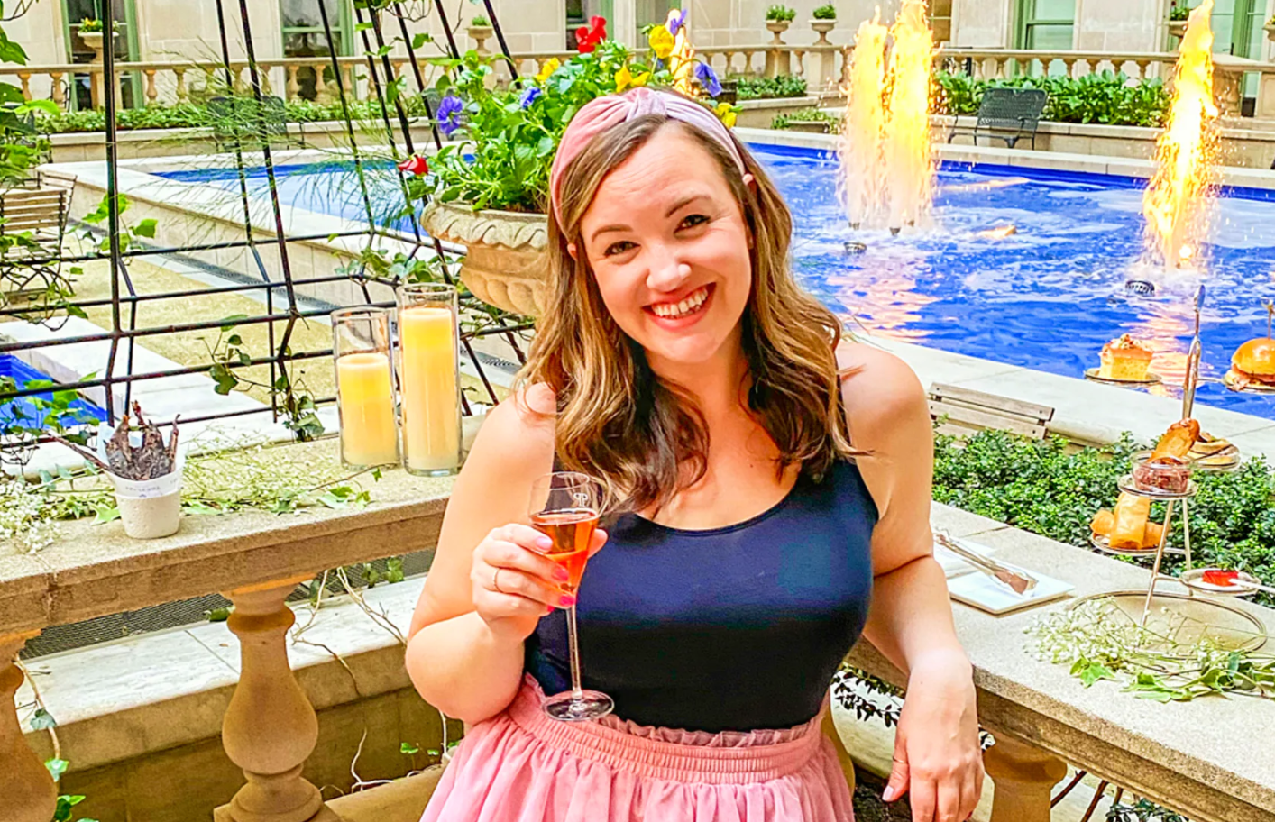 Lonely Planet's Caitlin Riddell holds a drink in front of a fountain inside the Plaza NYC