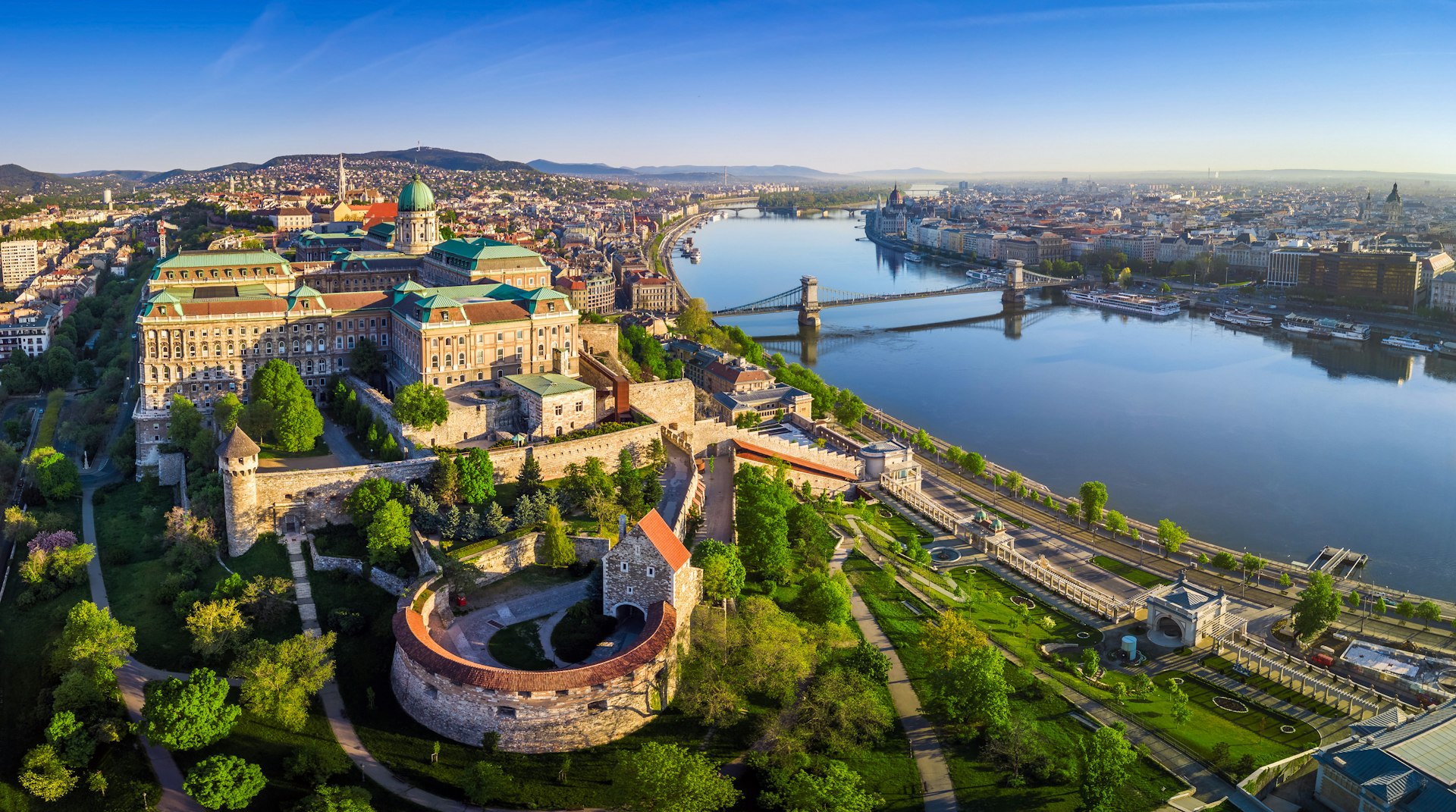 Early morning panoramic aerial of Buda Castle Royal Palace with Szechenyi Chain Bridge, St.Stephen's Basilica, Hungarian Parliament and Matthias