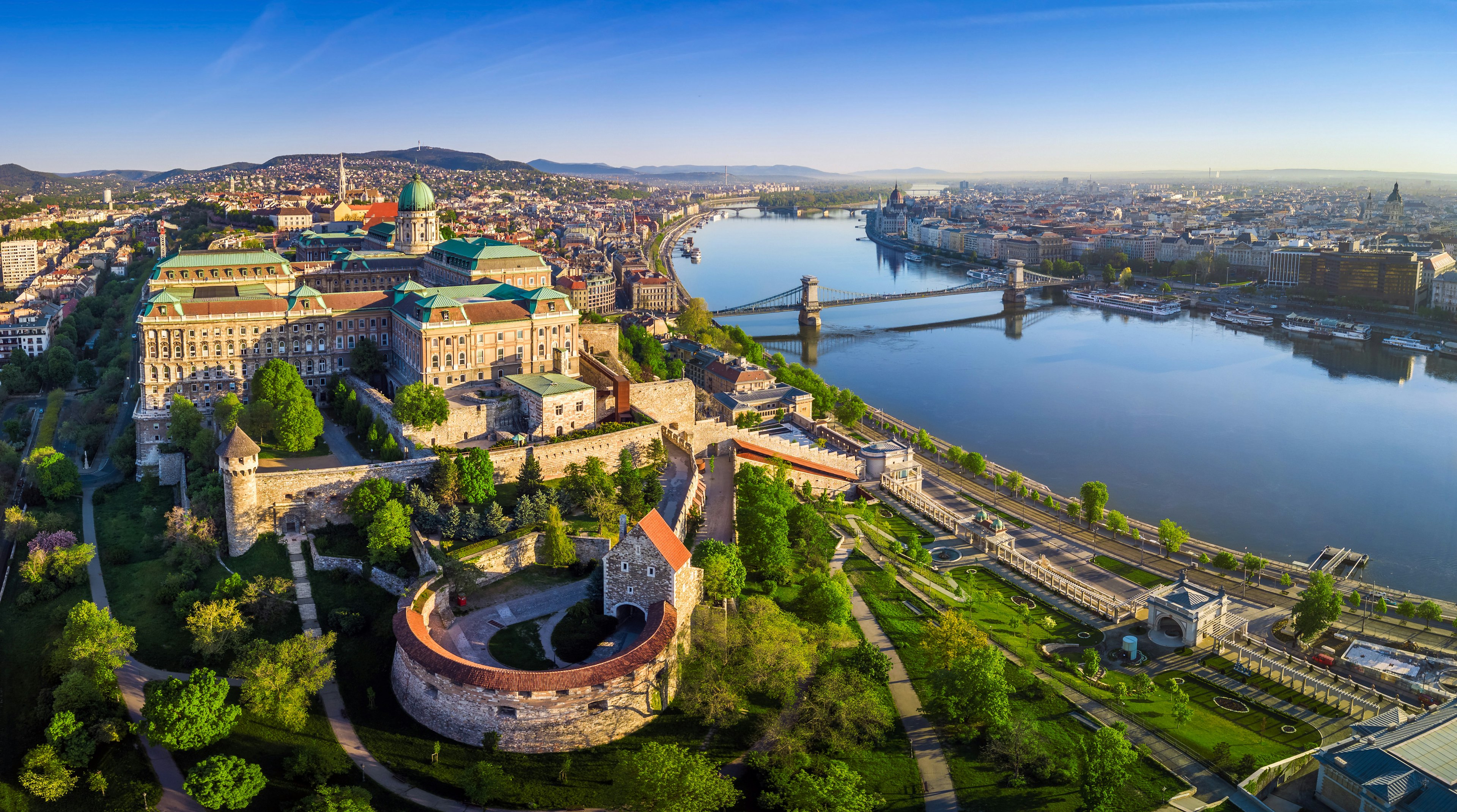 A panoramic, aerial view of Buda Castle Royal Palace, taken in the early morning, which also shows Széchenyi Chain Bridge, St Stephen's Basilica, the Hungarian Parliament and Matthias Church.