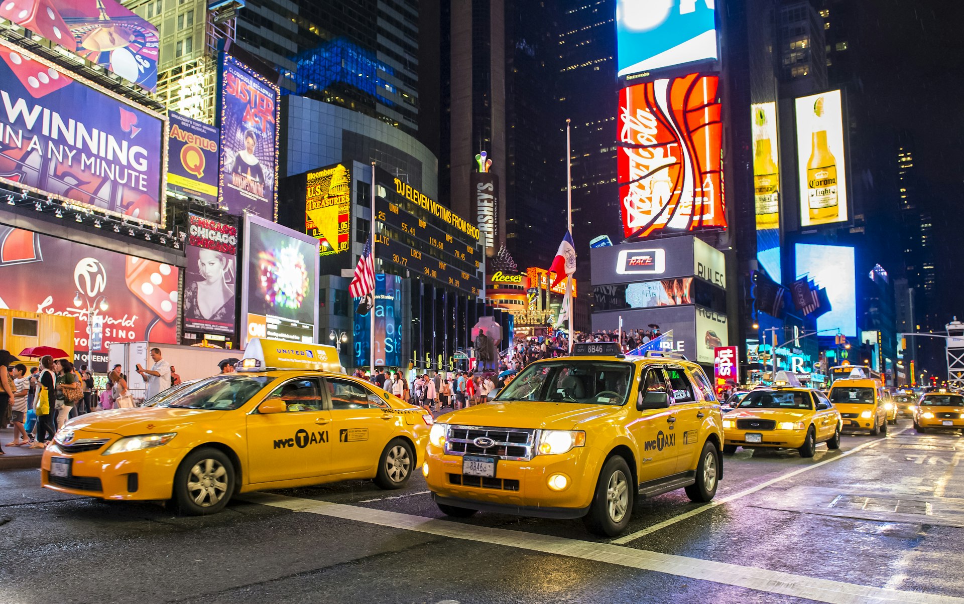 Yellow cabs traveling through Times Square at night