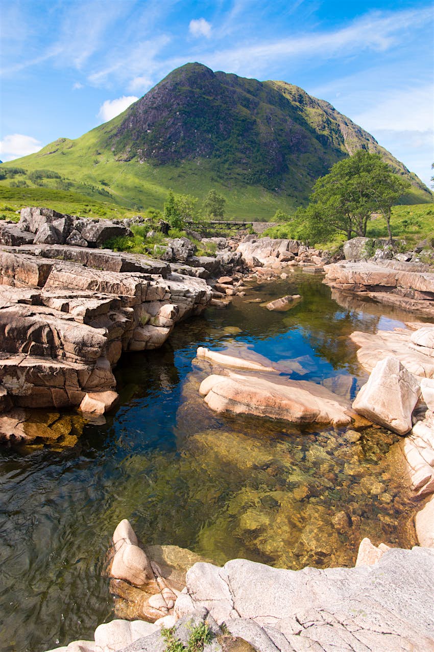 A river in the Glencoe valley, Scotland A clear pool of water with a huge mountain peak in the background