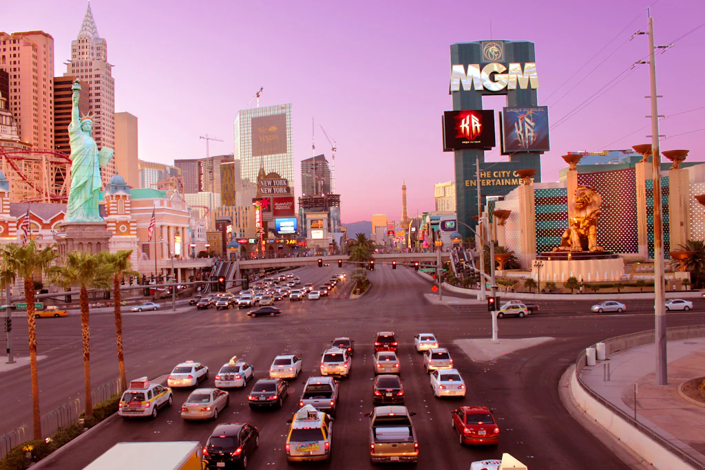 MGM Grand on the Las Vegas strip Queues of cars wait at the traffic lights on the Las Vegas strip near the intersection of the MGM Grand hotel and casino with a pink sunset in the background