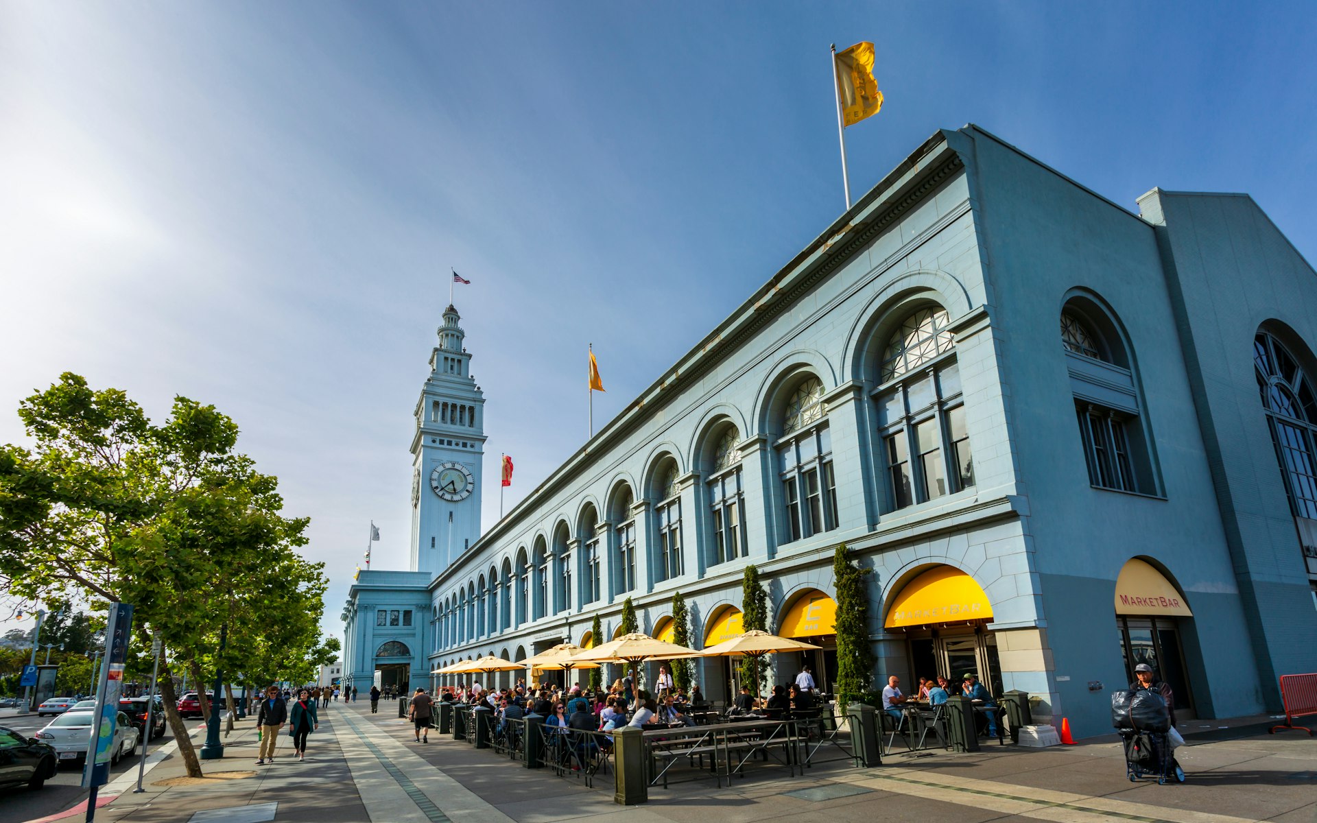 People walking outside of the Ferry Building, as seen from Mission Street in San Francisco. 
