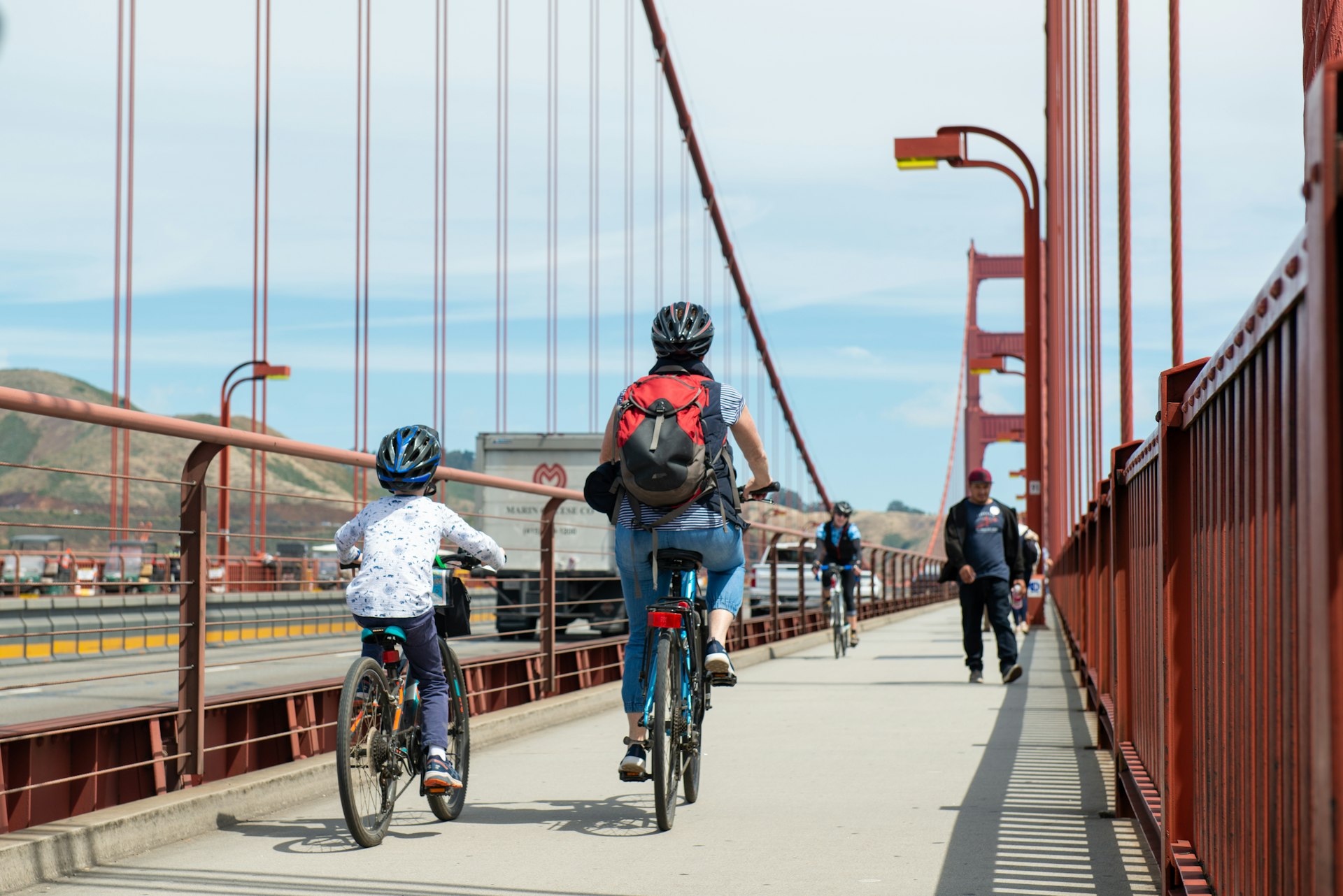 Two cyclists – an adult and a child – ride across the Golden Gate Bridge
