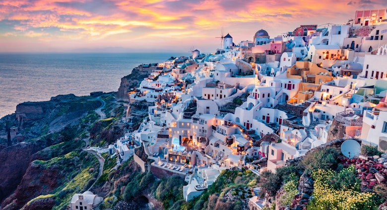 Summer sunset over the Greek town of Oia and the Mediterranean Sea.