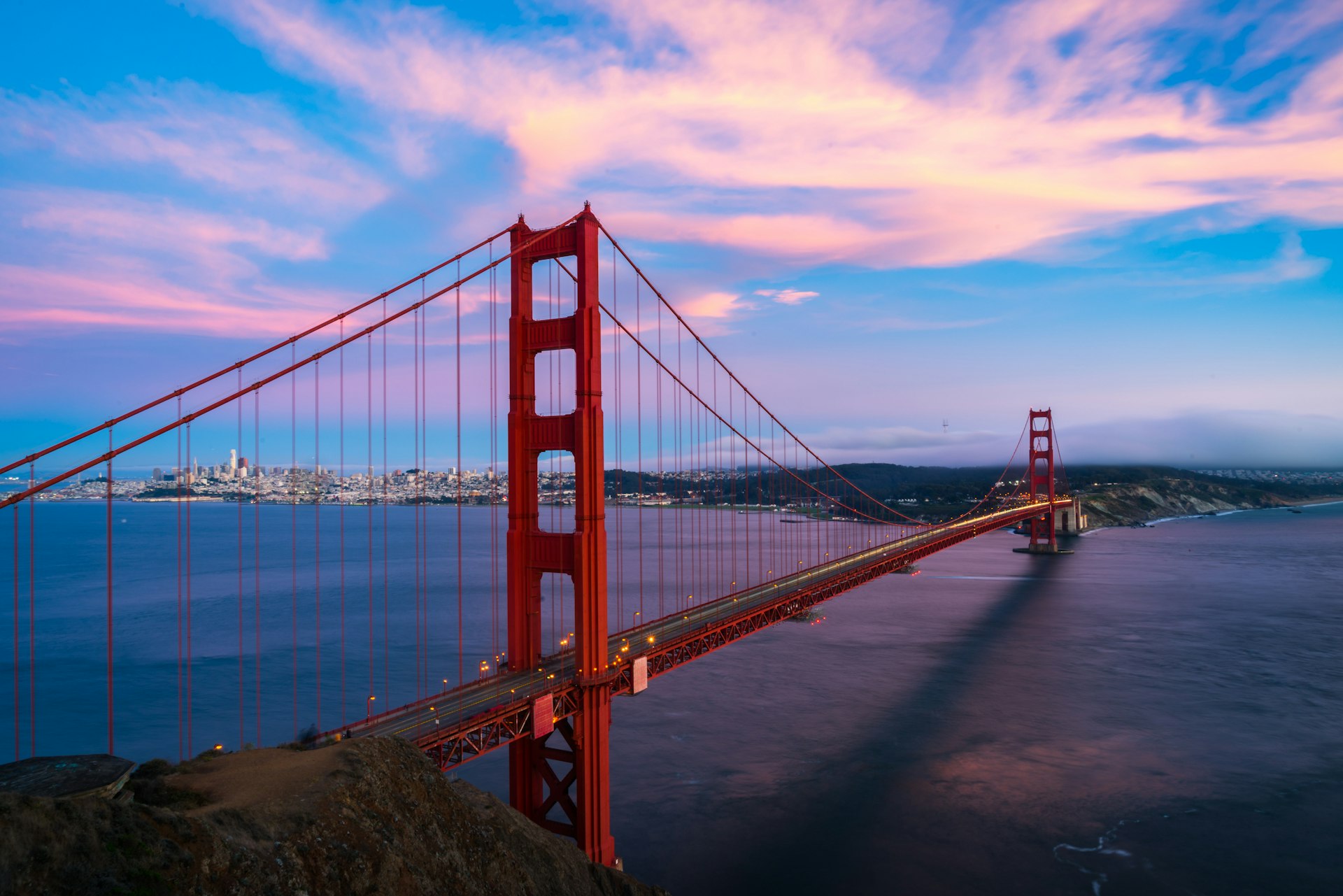 Pink clouds in the sky above the Golden Gate Bridge during sunrise