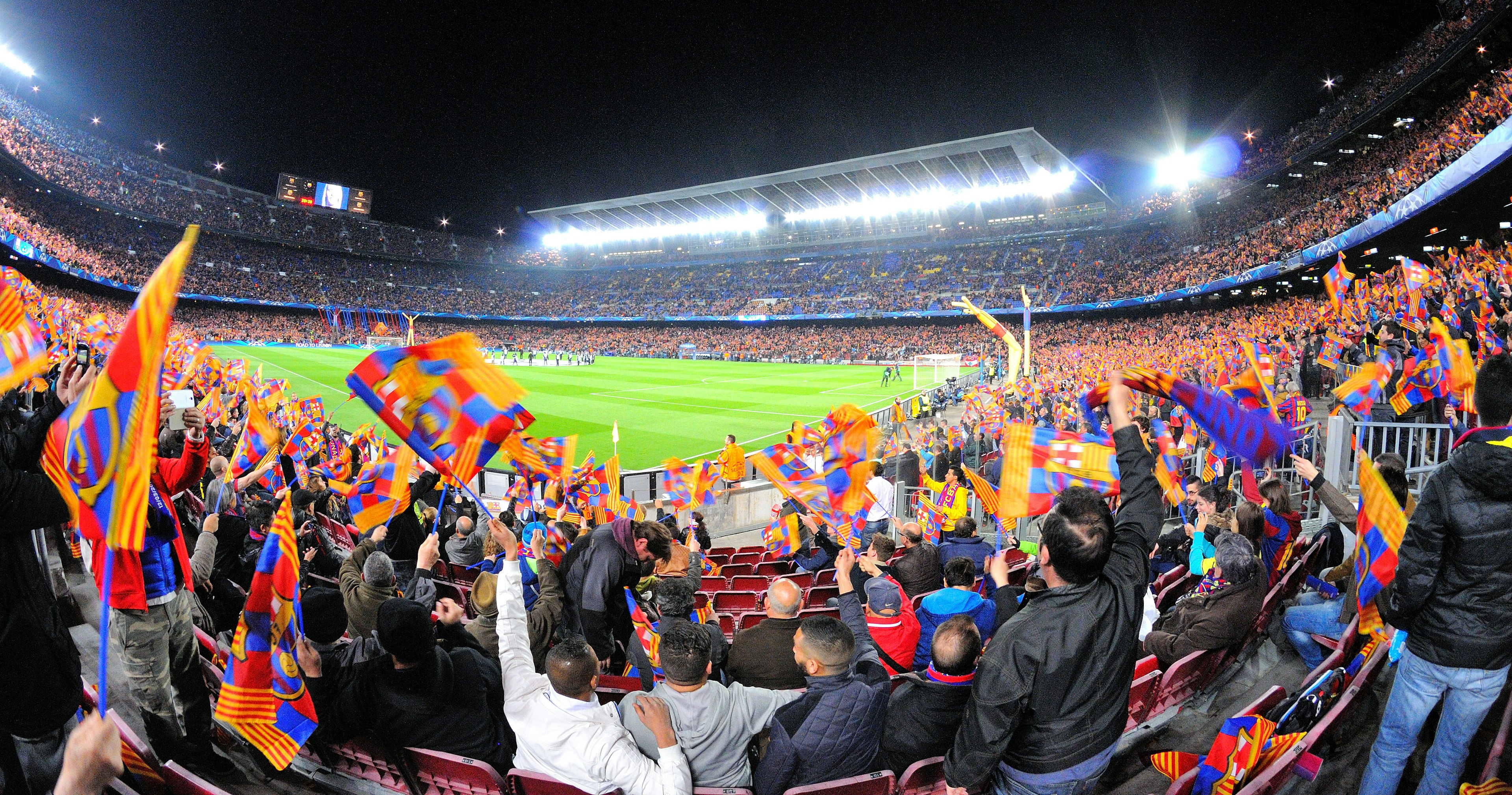 Soccer fans watch a game between Futbol Club Barcelona and Manchester City at Camp Nou in Barcelona