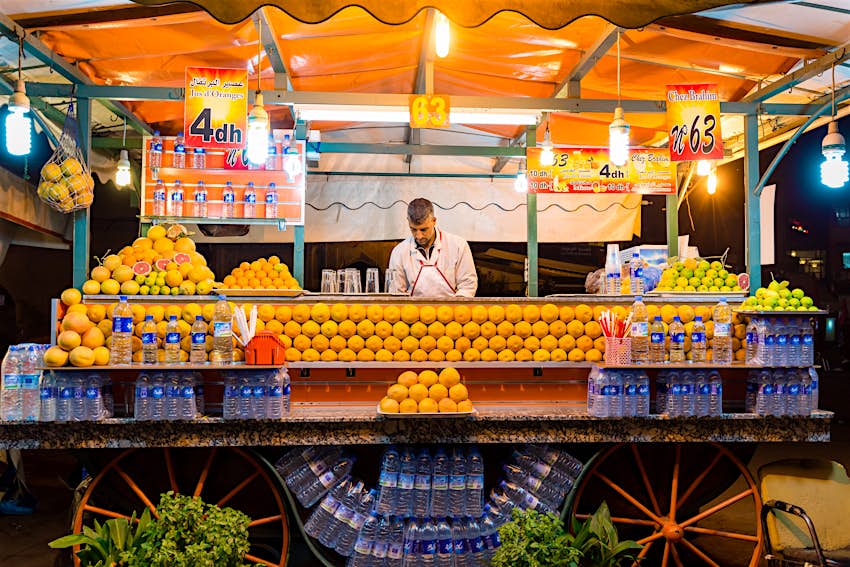 Man sells orange juice at a stall in Djemaa El Fna square in Marrakesh, Morocco