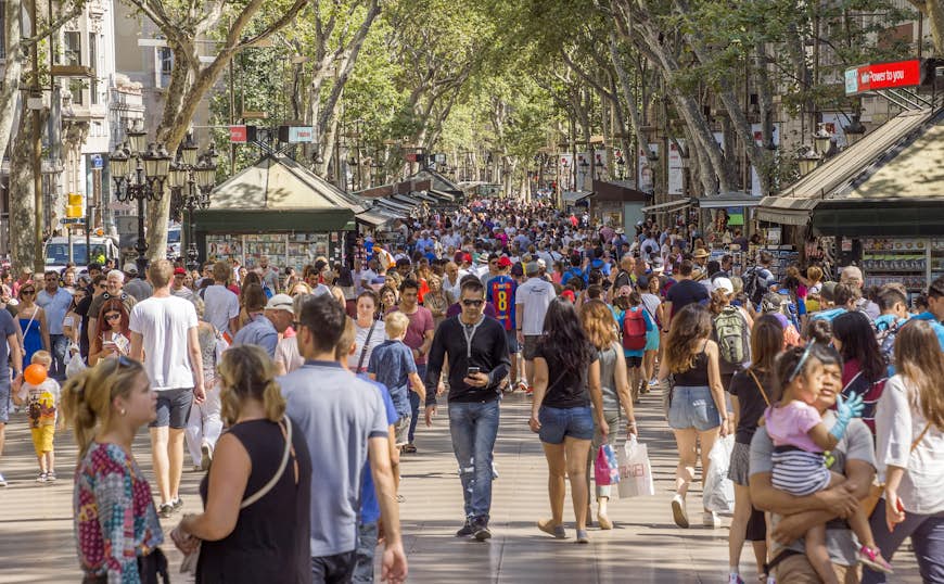 Hundreds of people walk along La Rambla, the famous pedestrian street in Barcelona