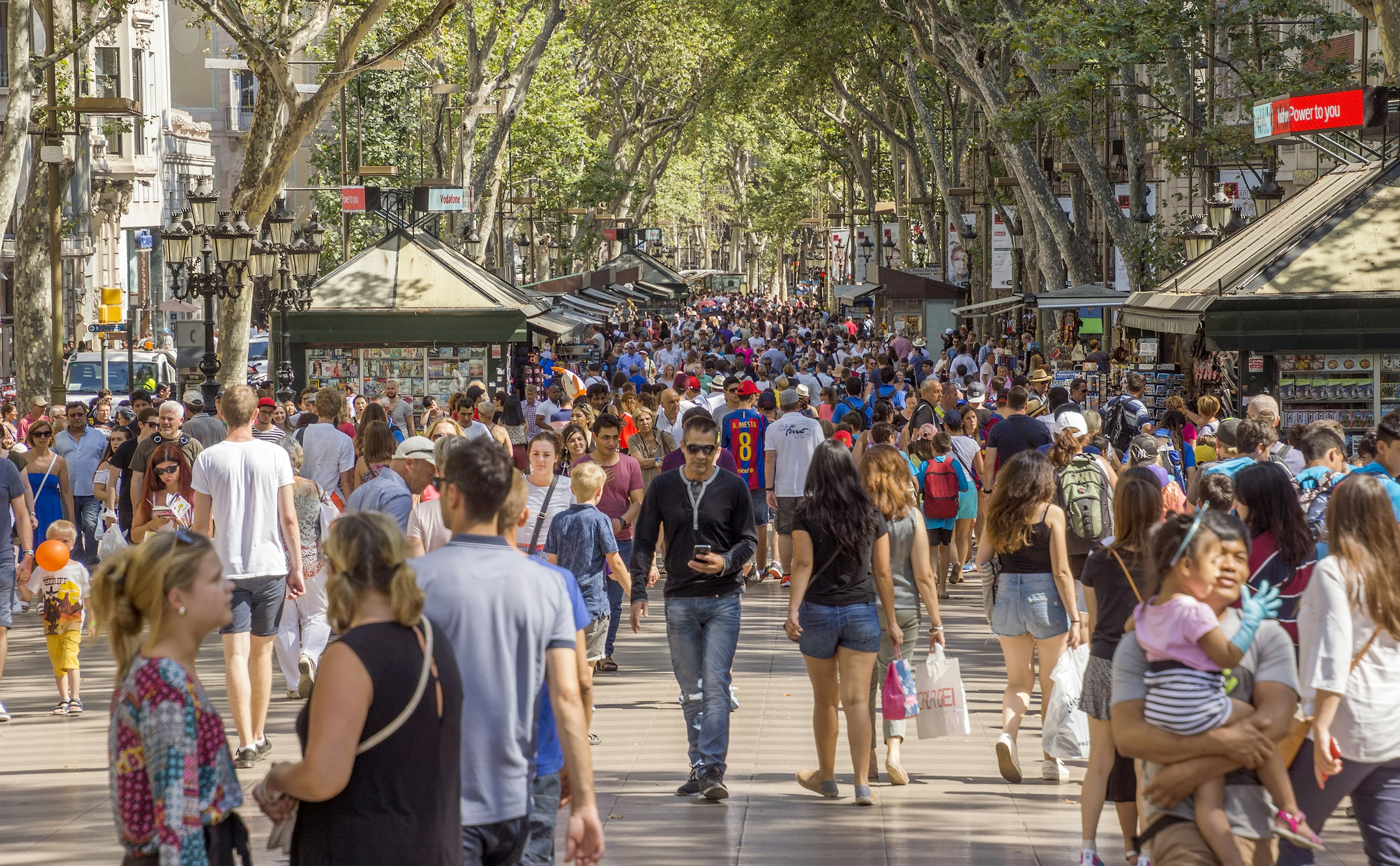 Hundreds of people walk along La Rambla, the famous pedestrian street in Barcelona