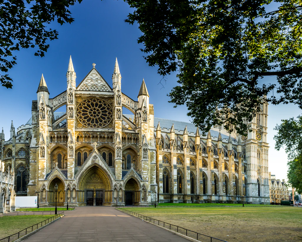 Exterior shot of a grand abbey building surrounded by green lawns