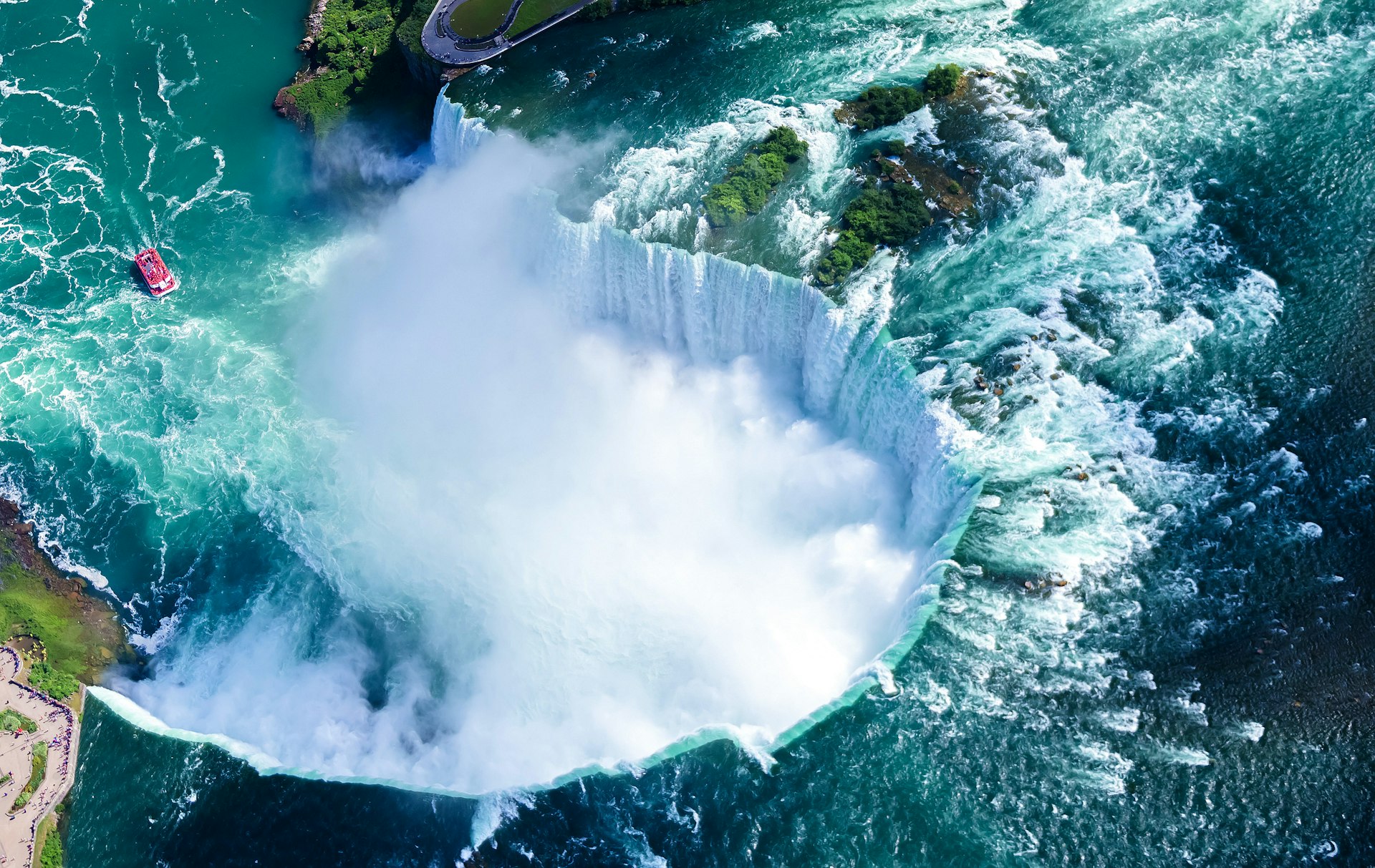 An aerial view shows a horseshoe-shaped waterfall. 