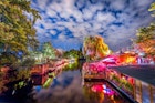 Panoramic view of young people partying in an open-air outdoor club at famous Flutgraben water canal on a beautiful warm summer night with moving clouds in Berlin Kreuzberg, Germany