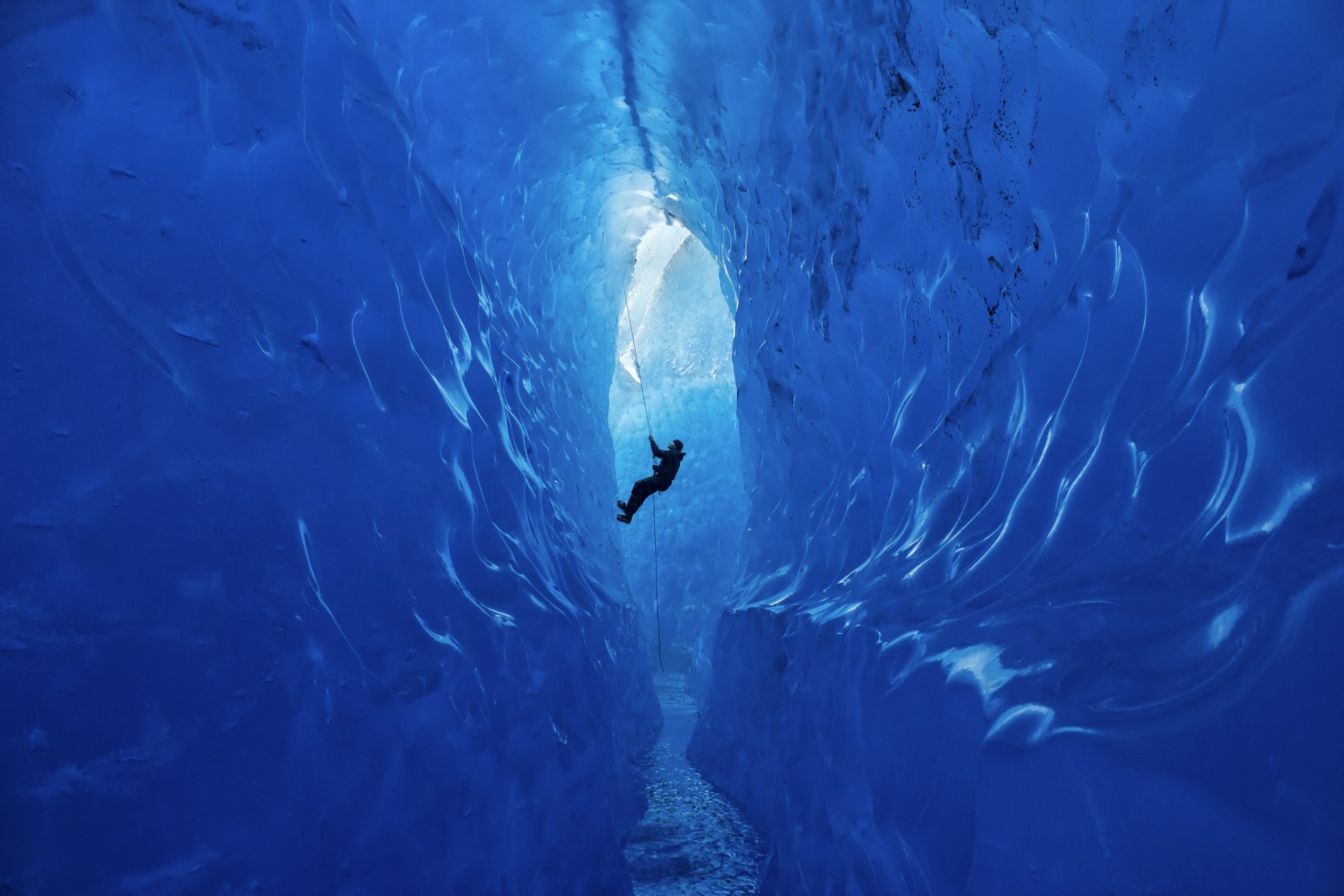 A climber rappels into an ice cave on the Mendenhall Glacier